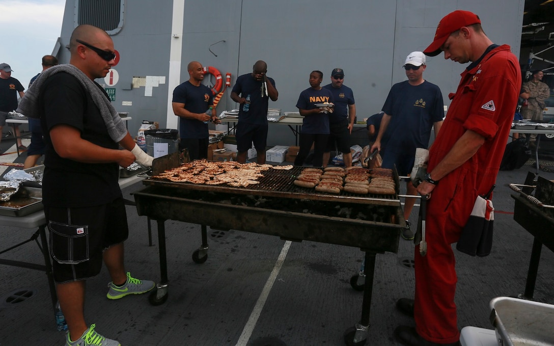 The Marines and Sailors of the 15th Marine Expeditionary Unit and USS Anchorage (LPD 23) cook on the grill at a steel beach picnic aboard the USS Anchorage in the Philippine Sea, June 4, 2015. The Marines and Sailors of the 15th MEU and Essex Amphibious Ready Group hold such events to boost morale and build camaraderie. (U.S. Marine Corps photo by Sgt. Steve H. Lopez/Released)