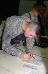 Army Spc. Carlos Villa Rivera, Wisconsin Guardmember with Headquarters Company, 1st Battalion, 147th Aviation Regiment, signs his passport application after becoming a U.S. citizen during a President's Day naturalization ceremony at one of Saddam Hussein's former Baghdad palaces at Camp Victory.