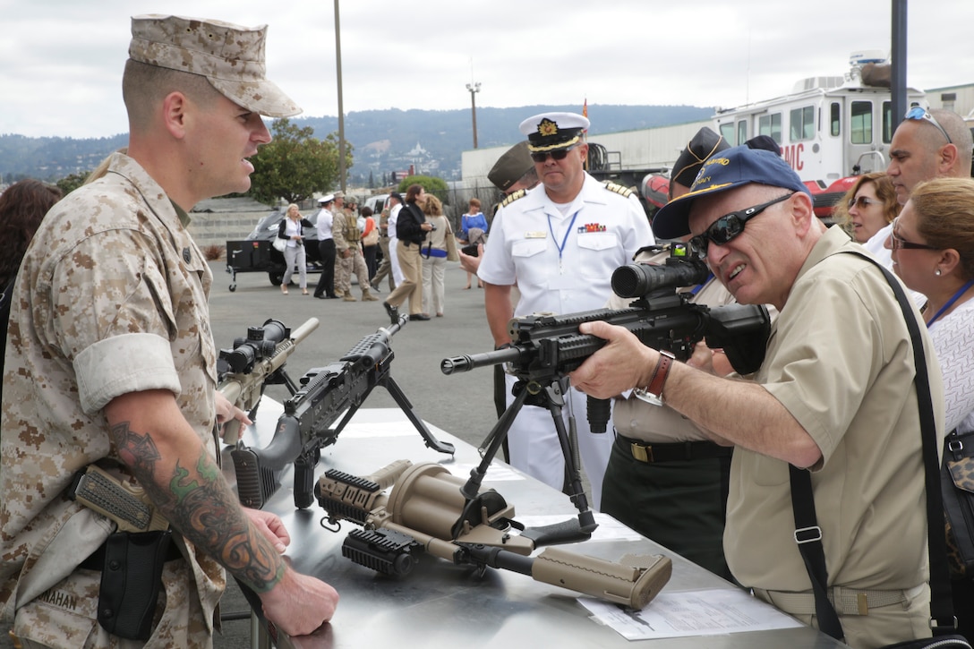 A flag officer handles a display rifle in Alameda, California, June 2, 2015. During the static display of weapons and gear presented by the Marines, Navy and flag officers were allowed to handle the equipment and ask questions. (U.S. Marine photo by Cpl. Ian Ferro)