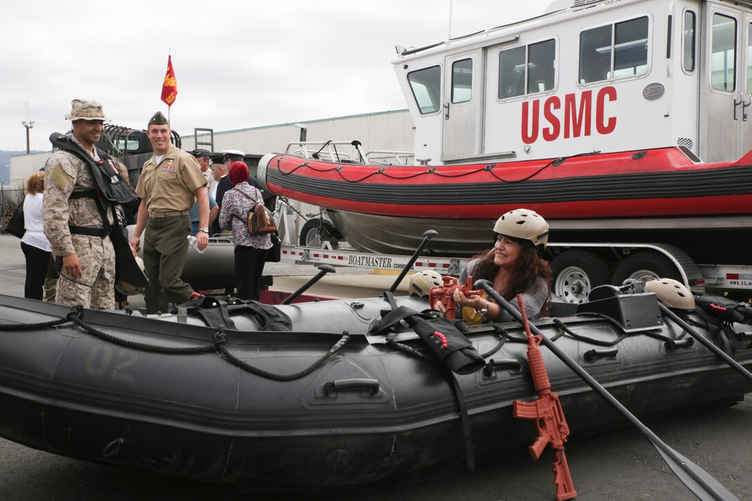A flag officer’s spouse gears up and poses for a photo in the Marine special operations Zodiac boat in Alameda, California, June 2, 2015. Marines welcomed foreign military attachés and their spouses, as well as members of the defense foreign liaison office, to a static display of vehicles, weapons and gear used by force reconnaissance Marines, during the attachés' regional tour. (U.S. Marine photo by Cpl. Ian Ferro)