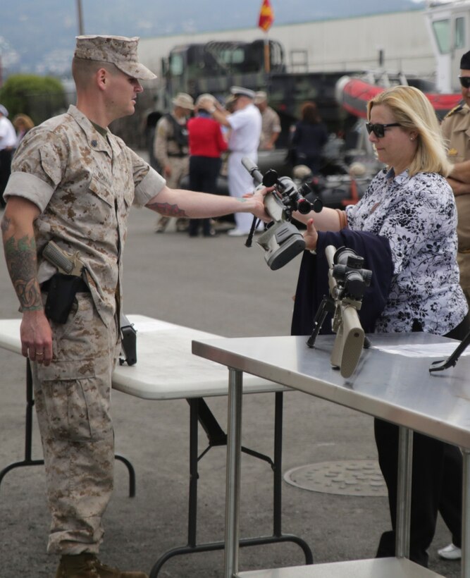 Staff Sgt. Thomas R. Monahan, Company Armorer, 4th Force Reconnaissance Company, 4th Marine Division, Marine Forces Reserve, hands a display rifle to a flag officer’s spouse in Alameda, California, June 2, 2015. Marines welcomed foreign military attachés and their spouses, as well as members of the defense foreign liaison office, to a static display of vehicles, weapons and gear used by force reconnaissance Marines, during the attachés' regional tour.. (U.S. Marine photo by Cpl. Ian Ferro)