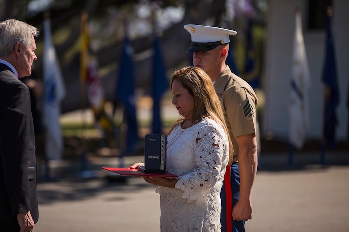 Secretary of the Navy Ray Mabus presents the Navy Cross to Rosa Peralta, the mother of the late Sgt. Rafael Peralta, during ceremony held in his honor aboard Camp Pendleton, Calif., June 8, 2015. Peralta was awarded the Navy Cross for his actions in support of Operation Al Fajr in Fallujah, Al Anbar province, Iraq, on Nov. 15, 2004, where he covered an enemy grenade with his body protect his fellow Marines. (U.S. Marine Corps photo by Lance Cpl. Clarence A. Leake/Released)