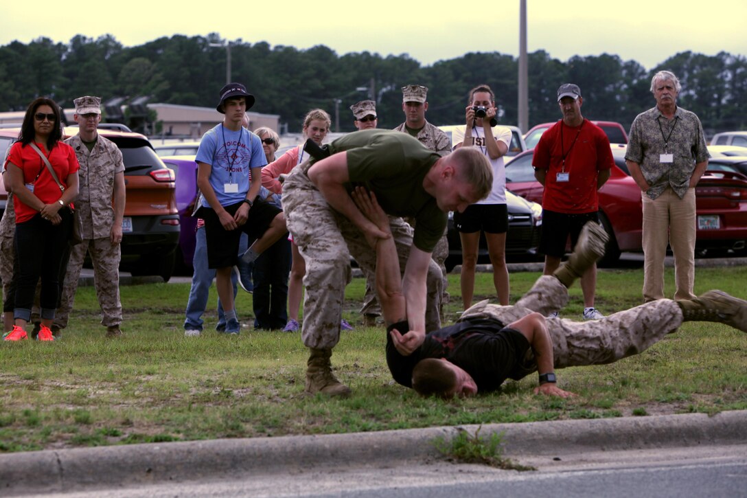 Staff Sgt. Scott Grimmer and Sgt. Aaron Marcusen demonstrate a “take down” from the Marine Corps Martial Arts Program for Maines and family members of Marine Wing Communications Squadron 28 during an “All Access Pass” event at Marine Corps Air Station Cherry Point, N.C., June 5, 2015. MWCS-28 hosted the event to give families an opportunity to see and learn about their Marines’ daily work life, build relationships with the command, meet other families and build camaraderie with the unit and its leadership.