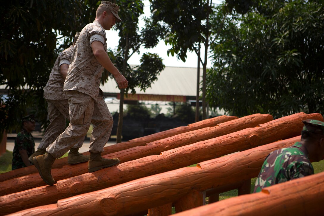 U.S. Marine Cpl. Steven Mowen, a U.S. Marine Corps Forces, Pacific Band tuba player, goes through the Indonesian Korps Marinir obstacle course during a tour of the 2nd Marine Force, Jakarta Marine Base, June 3, 2015. The obstacle course is similar to the Marine Corps', but has 10 more obstacles. Musicians from both countries' bands practiced together and shared their knowledge on music throughout the day, culminating in a concert for Indonesian KORMAR aboard the base. This is the first time the two bands have played together.