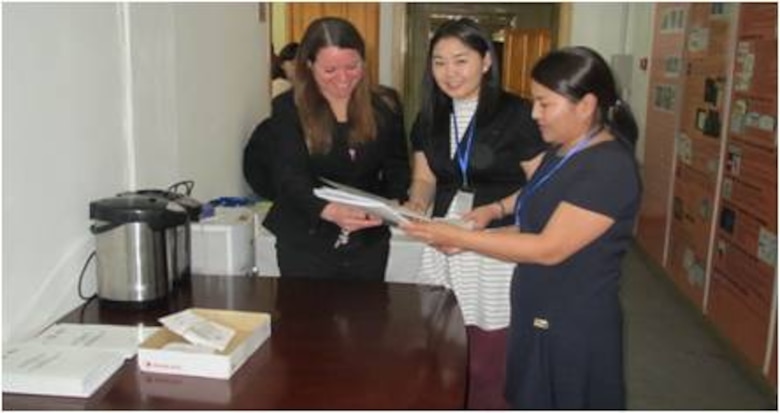 US Army Corps of Engineers Far East District operations officer Maj. L. Dot Browning greeting participants and handing out workshop materials during a water resource management strategy workshop in Ulaanbaatar, Mongolia.