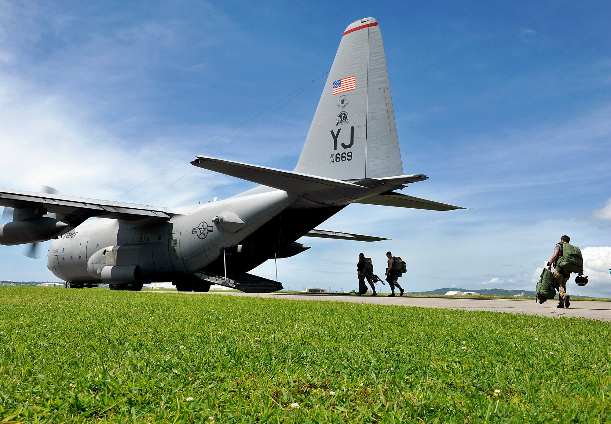 U.S. Air Force pararescuemen from the 31st Rescue Squadron walk toward a 36th Airlift Squadron C-130 Hercules on Kadena Air Base, Japan, before flying to Ie Shima Island auxiliary airfield for jump training June 8, 2015. Fourteen pararescuemen from 31st RQS participated in the jump training in order to maintain proficiency. (U.S. Air Force photo by Naoto Anazawa)