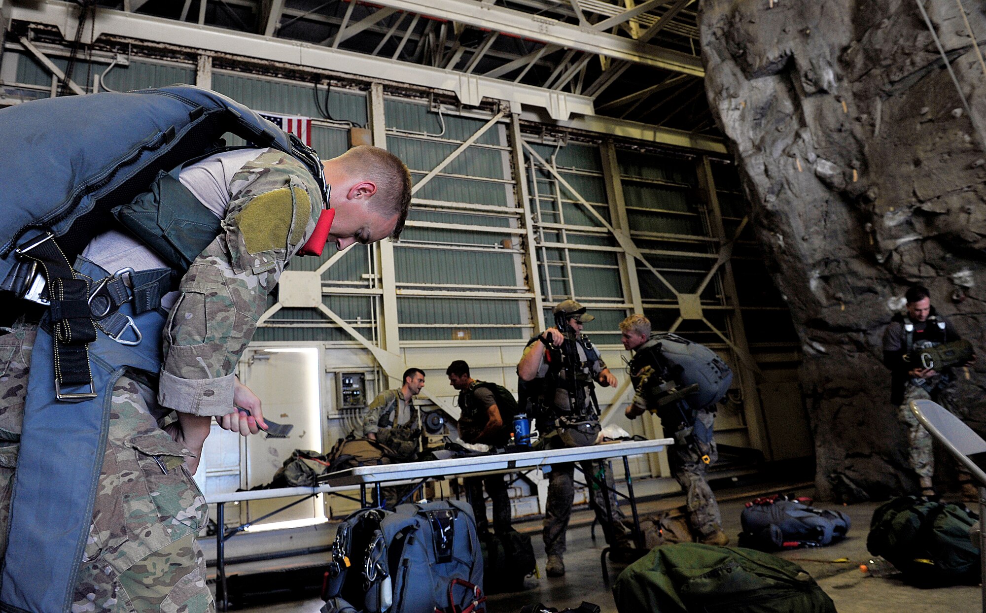 U.S. Air Force pararescuemen from the 31st Rescue Squadron don parachute equipment on Kadena Air Base, Japan, before flying to Ie Shima Island auxiliary airfield for jump training June 8, 2015. The training was part of routine training for the 31st Rescue Squadron. (U.S. Air Force photo by Naoto Anazawa)