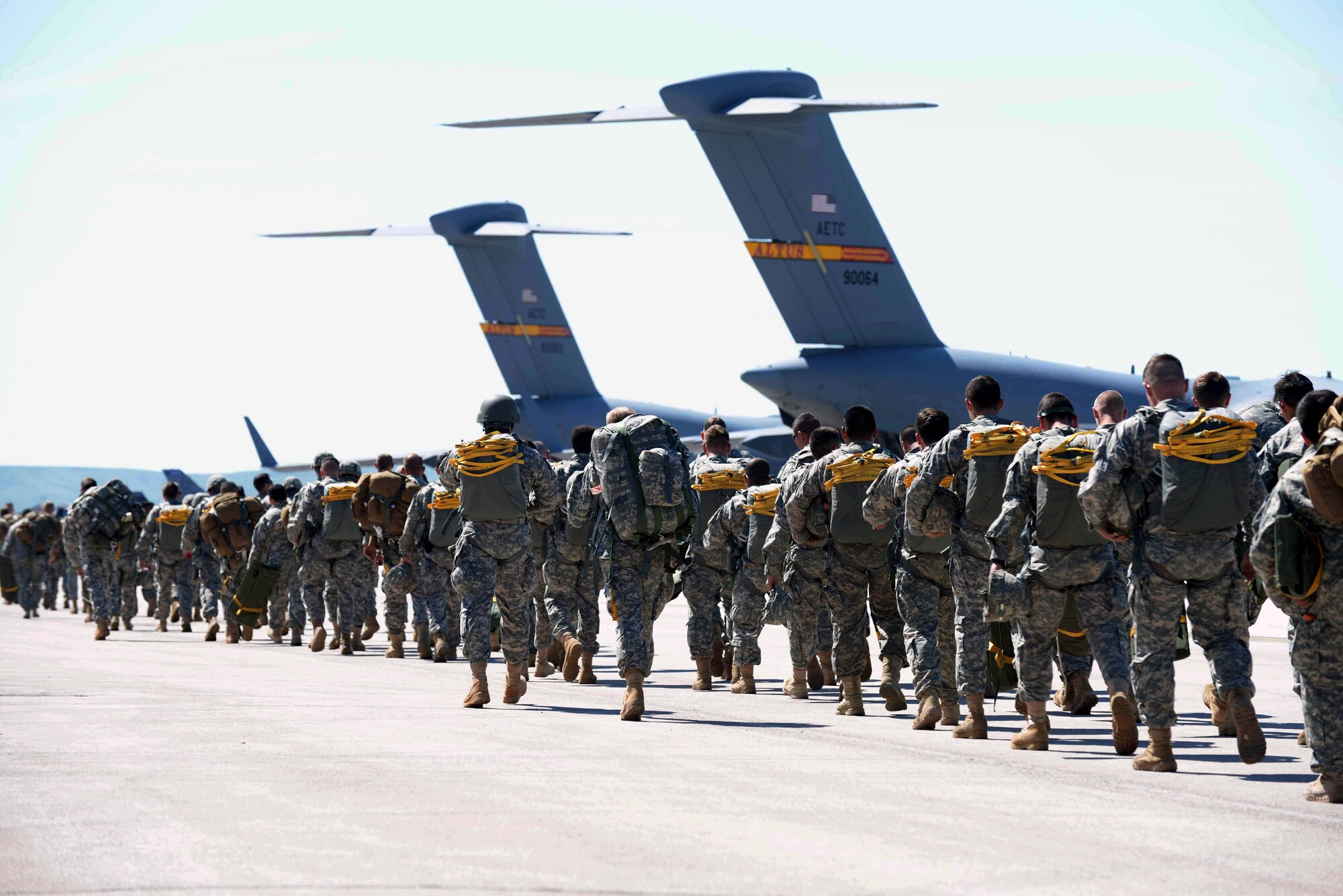 Approximately 200 Guardsmen from the 1st Battalion 143rd Infantry Regiment Airborne from Austin, Texas, prepare to board two C-17 Globemaster III aircraft assigned to Altus Air Force Base, Okla., as part of Golden Coyote at Ellsworth Air Force Base, S.D., June 8, 2015. Created in 1984 by the South Dakota National Guard, with the cooperation of the National Forest Service and Custer State Park, this year's Golden Coyote training exercise will allow nearly 3,000 servicemembers to conduct combat support and combat service support missions in a realistic training environment and provide valuable services to the public. More than 15 base agencies are contributing to the 31st Annual Golden Coyote exercise by providing lodging, food services and medical aid, among other capabilities, to ensure the success of the exercise. (U.S. Air Force photo by Airman 1st Class Rebecca Imwalle/Released)