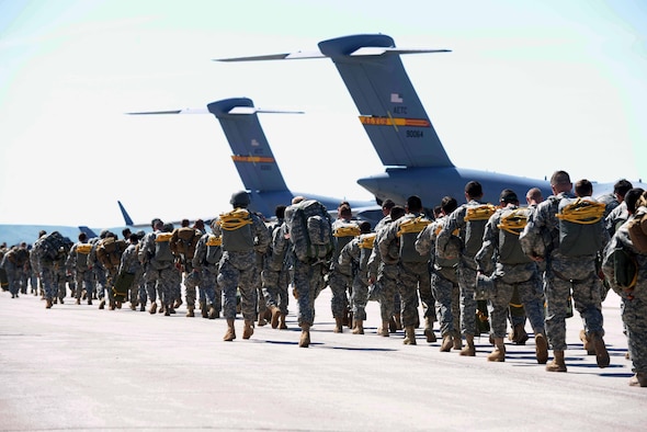 Approximately 200 Guardsmen from the 1st Battalion 143rd Infantry Regiment Airborne from Austin, Texas, prepare to board two C-17 Globemaster III aircraft assigned to Altus Air Force Base, Okla., as part of Golden Coyote at Ellsworth Air Force Base, S.D., June 8, 2015. Created in 1984 by the South Dakota National Guard, with the cooperation of the National Forest Service and Custer State Park, this year's Golden Coyote training exercise will allow nearly 3,000 servicemembers to conduct combat support and combat service support missions in a realistic training environment and provide valuable services to the public. More than 15 base agencies are contributing to the 31st Annual Golden Coyote exercise by providing lodging, food services and medical aid, among other capabilities, to ensure the success of the exercise. (U.S. Air Force photo by Airman 1st Class Rebecca Imwalle/Released)