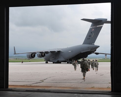 National Guardsmen from the 1st Battalion 143rd Infantry Regiment Airborne from Austin, Texas, unload a C-17 Globemaster III behind the Pride Hangar on Ellsworth Air Force Base, S.D., June 5, 2015. Approximately 120 Guardsmen arrived on Day One of the 31st Annual Golden Coyote exercise in which 35 military units representing 12 states will team up with military members from three foreign nations to create an invaluable training experience. (U.S. Air Force photo by Airman Sadie Colbert/Released)