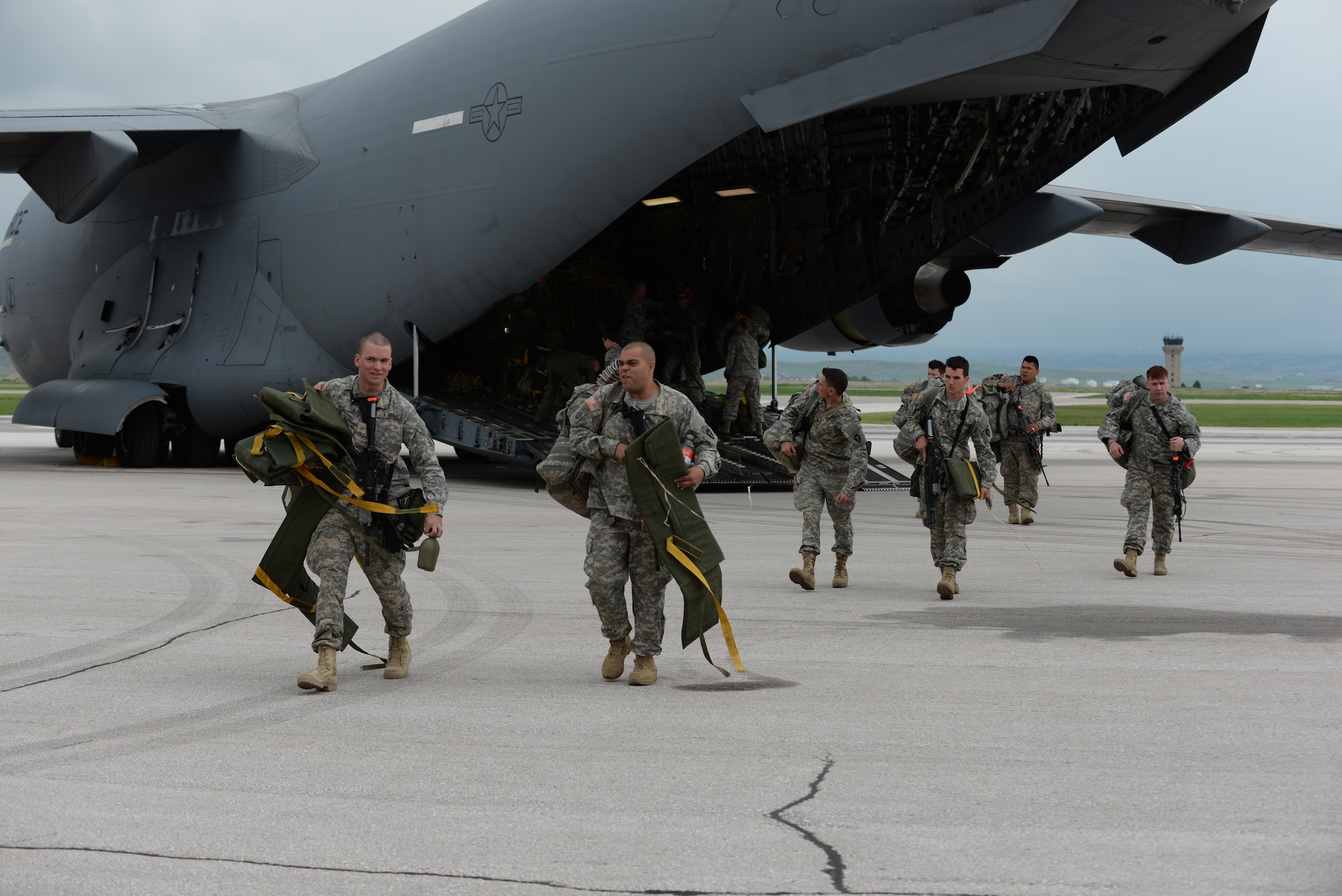 National Guardsmen from the 1st Battalion 143rd Infantry Regiment Airborne from Austin, Texas, unload from a C-17 Globemaster III in support of Golden Coyote at Ellsworth Air Force Base, S.D., June 5, 2015. More than 120 Guardsmen from across the nation exited the aircraft to set up camp in the Pride Hangar in preparation for the 31st iteration of the exercise where participants engage in realistic training scenarios focused on honing skills required for overseas contingency operations and homeland defense. (U.S. Air Force photo by Master Sgt. John Barton/Released)