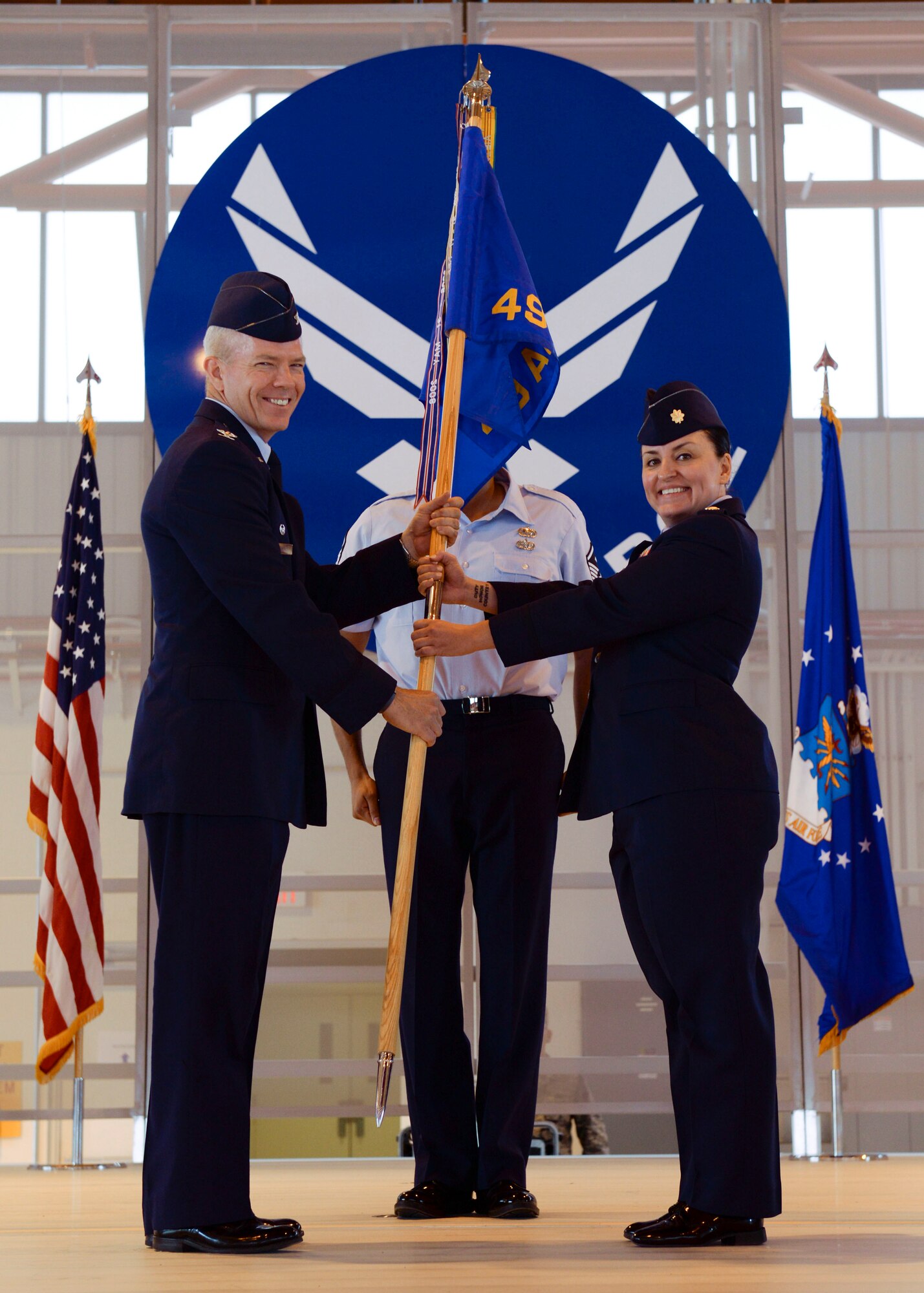 Col. Michael Shea, the 49th Maintenance Group commander, passes the 49th Aircraft Maintenance Squadron guidon to Maj. Rebecca A. Hart, the 49th Aircraft Maintenance incoming commander, symbolizing a seamless Change of Command at Holloman Air Force Base, N.M. June 9, 2015. During the Change of Command, Shea was the presiding officer and Maj. Rebecca A. Hart, the 49th AMXS incoming commander, assumed command. The 49th AMXS has 359 assigned Airmen to maintain nine MQ-1B Predator remotely piloted aircraft in support of the 6th Reconnaissance Squadron, 22 MQ-9A Reaper remotely piloted aircraft in support of the 9th and 29th Attack Squadrons and 11 ground control stations and associated satellite communications assets that encompass command and control capability for the aircraft. (U.S. Air Force photo by Staff Sgt. E’Lysia A. Wray/Released)