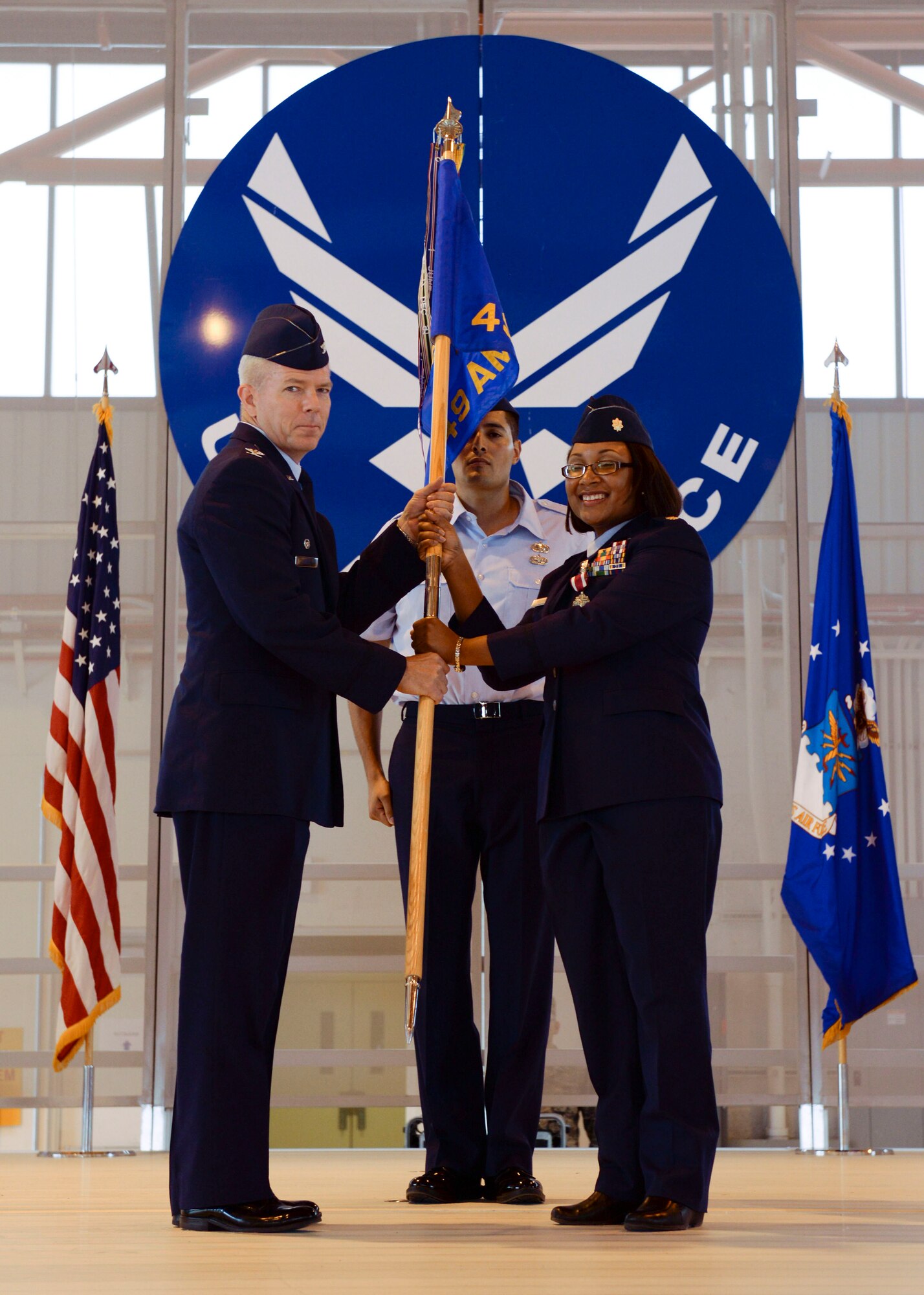 Col. Michael Shea, the 49th Maintenance Group commander, accepts the 49th Aircraft Maintenance Squadron guidon from Maj. Jeurney K. Meekins, the 49th AMXS outgoing commander, symbolizing a seamless Change of Command at Holloman Air Force Base, N.M. June 9, 2015. During the Change of Command, Shea was the presiding officer and Maj. Rebecca A. Hart, the 49th AMXS incoming commander, assumed command. The 49 AMXS generates over 73 thousand flight hours annually in support of the Air Force's largest and fastest growing Formal Training Unit and combat operations around the world.  Additionally, the 49 AMXS maintains a continuous forward presence with nearly 15 percent of assigned Airmen deployed in support of combat and humanitarian operations for multiple Combatant Commanders.  Finally, the squadron manages aircraft and resources valued at over $402 million and execute a $2.4 million budget. (U.S. Air Force photo by Staff Sgt. E’Lysia A. Wray/Released)