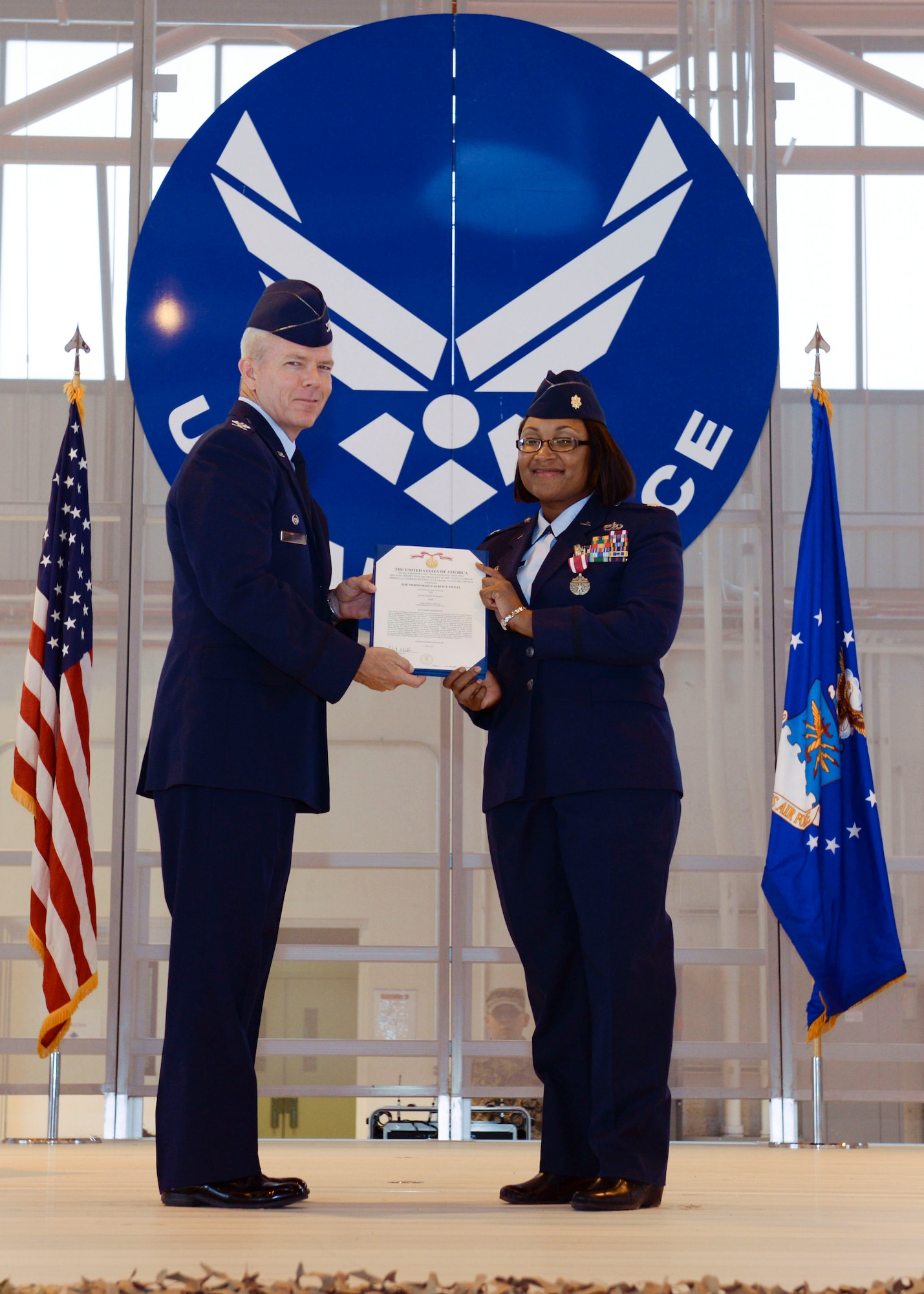 Col. Michael Shea, the 49th Maintenance Group commander, presents Maj. Jeurney K. Meekins, the 49th Aircraft Maintenance Squadron outgoing commander, a decoration to acknowledge her many accomplishments at Holloman Air Force Base, N.M. June 9, 2015. During the Change of Command, Shea was the presiding officer and Maj. Rebecca A. Hart, the 49th AMXS incoming commander, assumed command. The 49th AMXS has 359 assigned Airmen to maintain nine MQ-1B Predator remotely piloted aircraft in support of the 6th Reconnaissance Squadron, 22 MQ-9A Reaper remotely piloted aircraft in support of the 9th and 29th Attack Squadrons and 11 ground control stations and associated satellite communications assets that encompass command and control capability for the aircraft. (U.S. Air Force photo by Staff Sgt. E’Lysia A. Wray/Released)