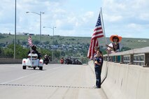 Residents of Great Falls, Mont., show their support as Missing in America Project motor cycle escorts riders pass in en route to a ceremony to honor the remains of six unclaimed Veterans June 5, 2015. Airmen and their families from Malmstrom Air Force Base lined the 10th Ave. South Bridge out of Great Falls and rendered a final salute to honor the service and sacrifice of the veterans, who were transferred and laid to rest in Montana State Cemetery at Fort Harrison in Helena, Montana.  (U.S. Air Force photo/Tech. Sgt. Chad Thompson)