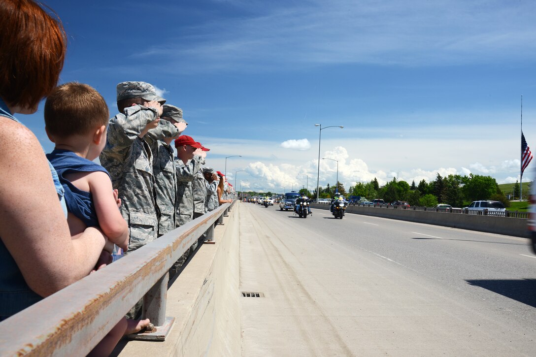 Residents of Great Falls, Mont., show their support as Missing in America Project motor cycle escorts riders pass in en route to a ceremony to honor the remains of six unclaimed Veterans June 5, 2015. Airmen and their families from Malmstrom Air Force Base lined the 10th Ave. South Bridge out of Great Falls and rendered a final salute to honor the service and sacrifice of the veterans, who were transferred and laid to rest in Montana State Cemetery at Fort Harrison in Helena, Montana.  (U.S. Air Force photo/Tech. Sgt. Chad Thompson)