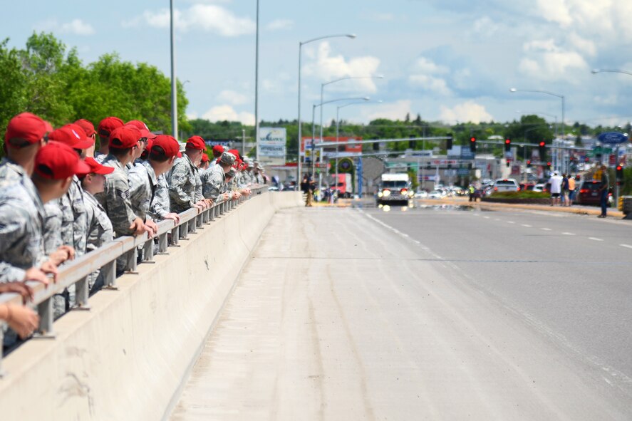 Residents of Great Falls, Mont., show their support as Missing in America Project motor cycle escorts riders pass in en route to a ceremony to honor the remains of six unclaimed Veterans June 5, 2015. Airmen and their families from Malmstrom Air Force Base lined the 10th Ave. South Bridge out of Great Falls and rendered a final salute to honor the service and sacrifice of the veterans, who were transferred and laid to rest in Montana State Cemetery at Fort Harrison in Helena, Montana.  (U.S. Air Force photo/Tech. Sgt. Chad Thompson)