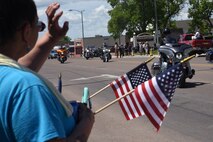 Residents of Great Falls, Mont., show their support as Missing in America Project motor cycle escorts riders pass in en route to a ceremony to honor the remains of six unclaimed Veterans June 5, 2015. 