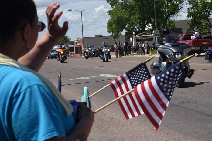 Residents of Great Falls, Mont., show their support as Missing in America Project motor cycle escorts riders pass in en route to a ceremony to honor the remains of six unclaimed Veterans June 5, 2015. 