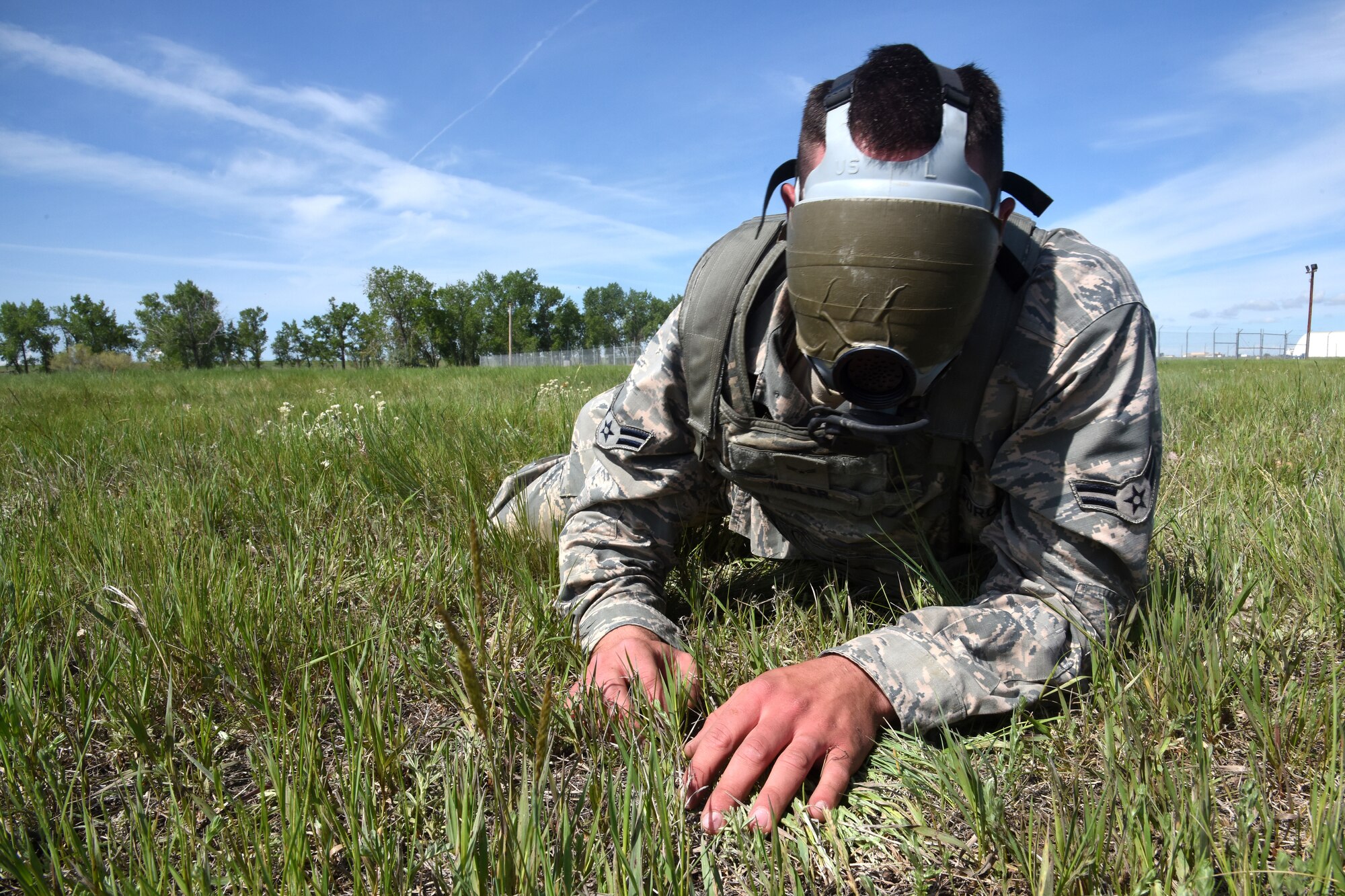A Team Malmstrom member crawls to a secure area while wearing a gas masked taped to block his vision at the Annual Aces Cop Combat Challenge June 5, 2015, at Malmstrom Air Force Base, Mont. This was the fourth annual challenge put on by security forces to encourage Airmen to push their body and mind outside of a normal routine. (U.S. Air Force photo/Chris Willis)