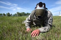 A Team Malmstrom member crawls to a secure area while wearing a gas masked taped to block his vision at the Annual Aces Cop Combat Challenge June 5, 2015, at Malmstrom Air Force Base, Mont. This was the fourth annual challenge put on by security forces to encourage Airmen to push their body and mind outside of a normal routine. (U.S. Air Force photo/Chris Willis)