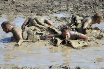 Team Malmstrom members from the 341st Security Forces Group work through sweat and mud while trying to accomplish multiple sets of team pushups in shallow water June 5, 2015, at Malmstrom Air Force Base, Mont. In total, 22 stations and events meant for security forces members to complete before judges determined the winning team. (U.S. Air Force photo/Chris Willis)