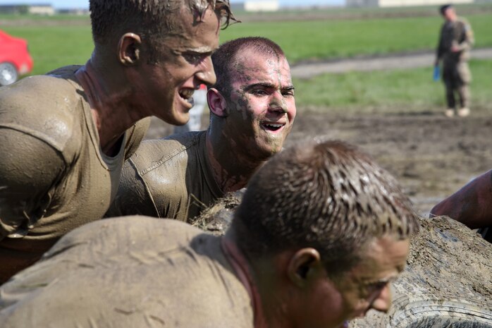 Team Malmstrom members from the 341st Security Forces Group work through sweat and mud while trying to move an oversize tire multiple times across a field June 5, 2015, at Malmstrom Air Force Base, Mont. Security Forces members had to complete 22 different challenging stations.  (U.S. Air Force photo/Chris Willis)