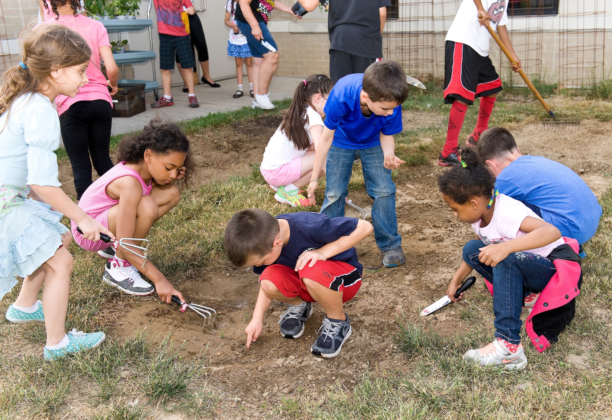 Children enrolled in the Before and After School Age program break up the soil for their garden May 27, 2015, at the Youth Center on Dover Air Force Base, Del. The garden is located on the east side of the Youth Center and will be cared for by children attending summer programs. (U.S. Air Force photo/Roland Balik)