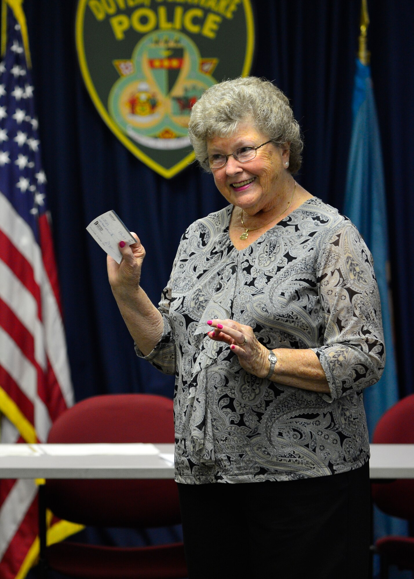 Eleanor Allione, Concerns of Police Survivors Delaware Chapter president, speaks to Delaware law enforcement chiefs after receiving an $8,000 check from the 436th Security Force Squadron June 9, 2015, at the Dover Police Department in Dover, Del. The money is going to be used by the C.O.P.S. organization to cover travel expenses for families to go to camps. (U.S. Air Force photo/Airman 1st Class William Johnson)