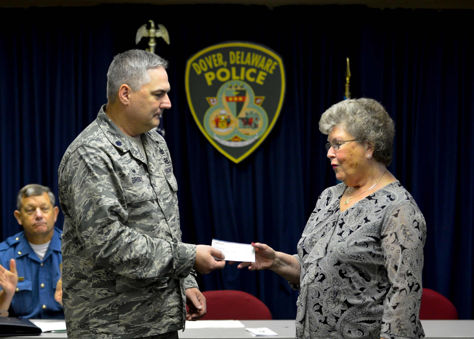Lt. Col. Joel Briske, then 436th Security Forces Squadron commander, presents Eleanor Allione, Concerns of Police Survivors Delaware Chapter president, with an $8,000 check June 9, 2015, at the Dover Police Department in Dover, Del. The money was raised from various fundraising events during Police Week by the 436th SFS to benefit the C.O.P.S. organization. (U.S. Air Force photo/Airman 1st Class William Johnson)