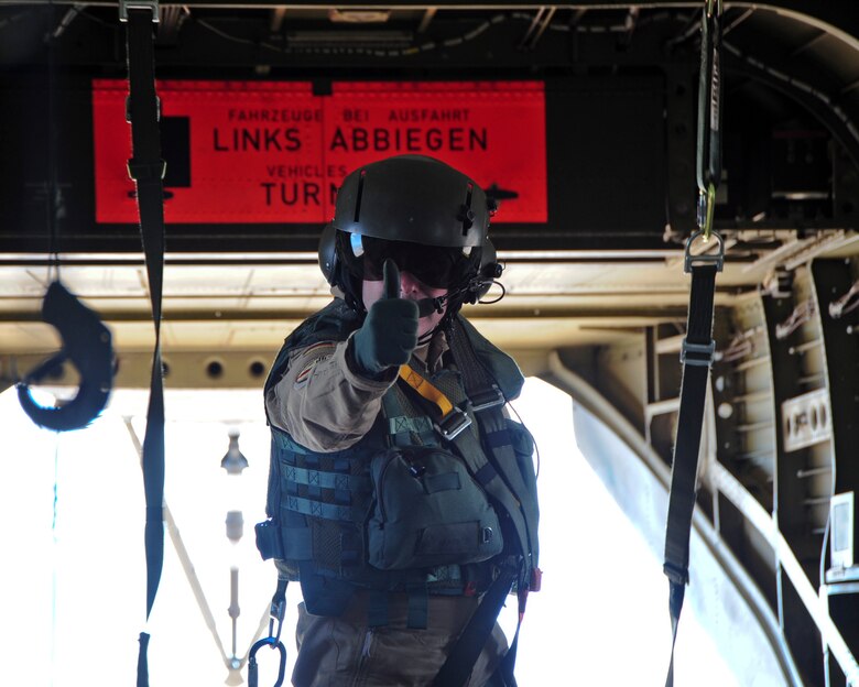 A German Air Force aerial gunner gives a "thumbs up" to passengers of the German Air Force CH-53GS helicopter signifying the aircraft is about to take off during Angel Thunder 2015 at Davis-Monthan Air Force Base, Ariz., June 7, 2015.  Angel Thunder is an Air Combat Command sponsored personnel recovery exercise for combat air force, joint, allied and interagency participants to come together and increase their knowledge about various recovery techniques.   (U.S. Air Force photo by Airman 1st Class Chris Massey/Released)