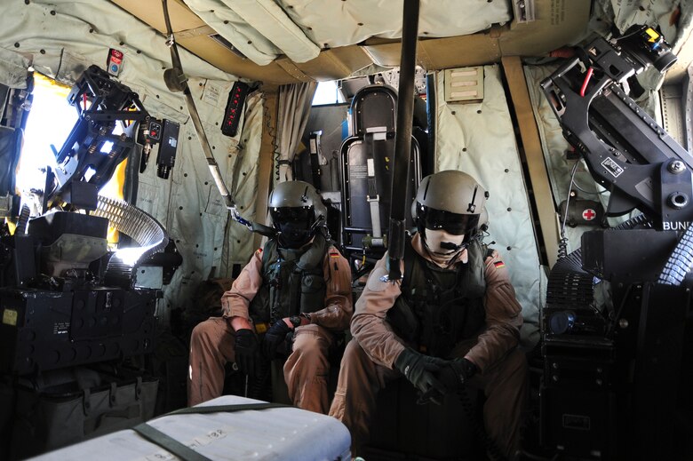Two German Air Force aerial gunners sit aboard a German Air Force CH-53GS helicopter during a departure from Davis-Monthan Air Force Base, Ariz., during Angel Thunder 2015, June 7, 2015.  Angel Thunder is the world's largest personnel recovery exercise.  D-M hosted 11 partner nations and nine interagencies with a common goal to train personnel recovery forces to prepare, plan, execute and adapt for rescue missions.  (U.S. Air Force photo by Airman 1st Class Chris Massey/Released)