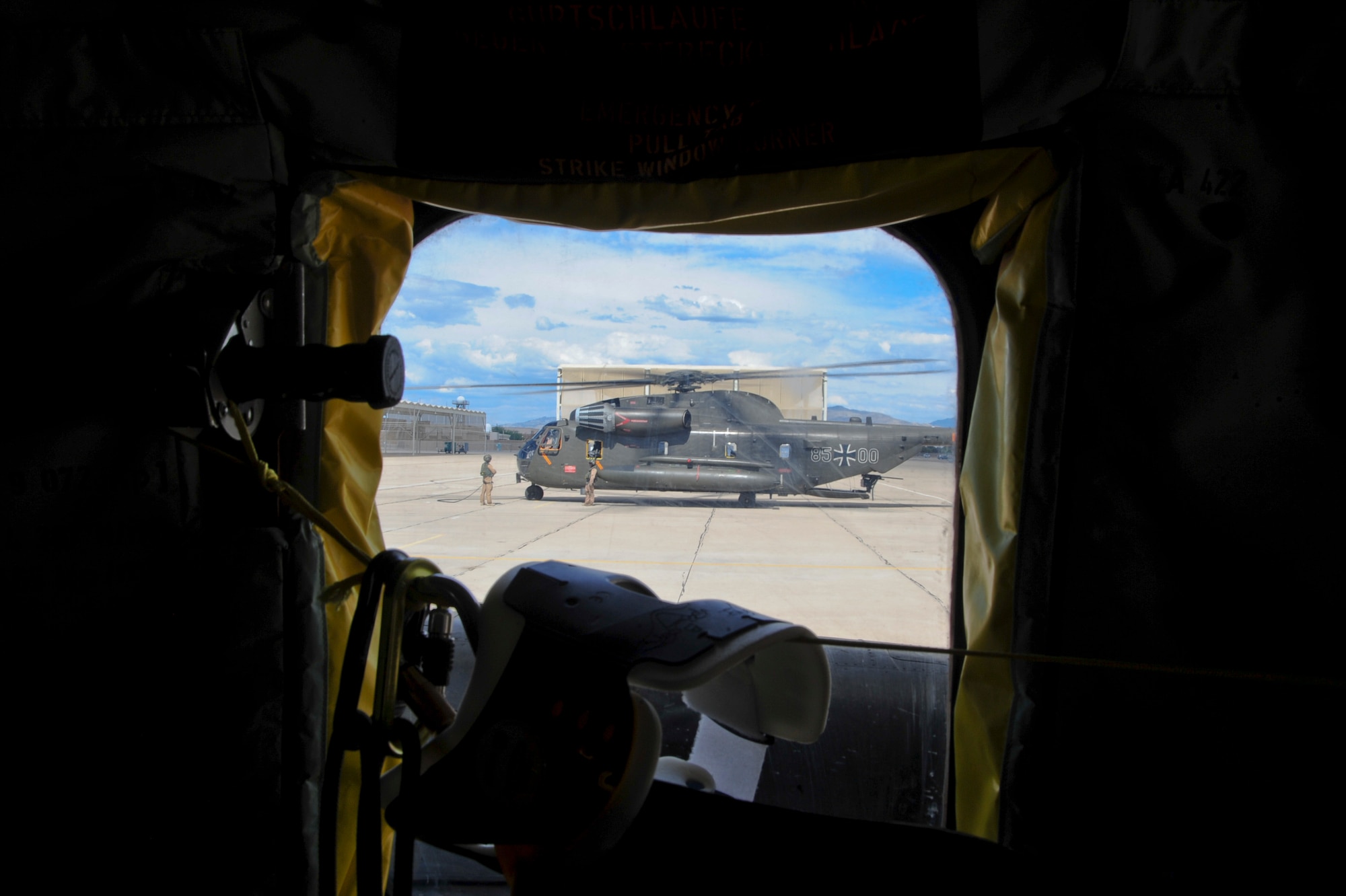 A German Air Force CH-53GS is seen through a window of its counterpart prior to takeoff from the flightline at Davis-Monthan Air Force Base, Ariz., during Angel Thunder 2015 June 7, 2015.  Angel Thunder is the world's largest personnel recovery exercise.  D-M hosted 11 partner nations and nine interagencies with a common goal to train personnel recovery forces to prepare, plan, execute and adapt for rescue missions.  (U.S. Air Force photo by Airman 1st Class Chris Massey/Released)