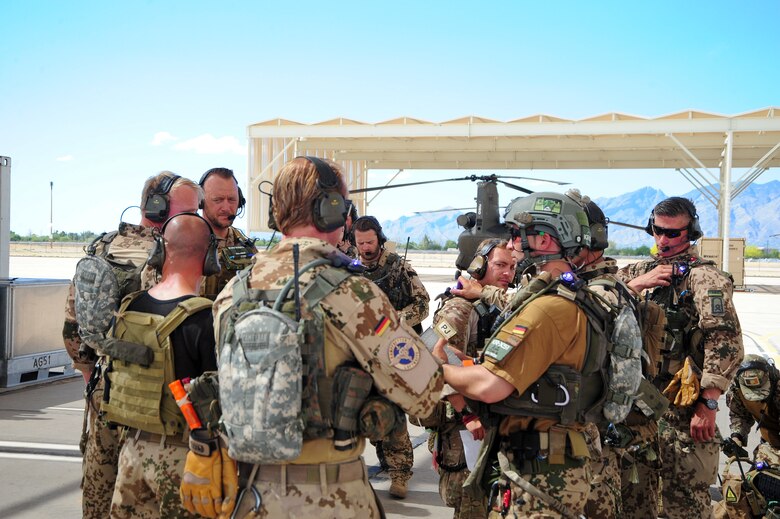German and U.S. Air Force pararescuemen check their radios before a training exercise during Angel Thunder 2015 at Davis-Monthan Air Force Base, Ariz., June 7, 2015.  Angel Thunder is the world's largest personnel recovery exercise.  D-M hosted 11 partner nations and nine interagencies with a common goal to train personnel recovery forces to prepare, plan, execute and adapt for rescue missions.   (U.S. Air Force photo by Airman 1st Class Chris Massey/Released)