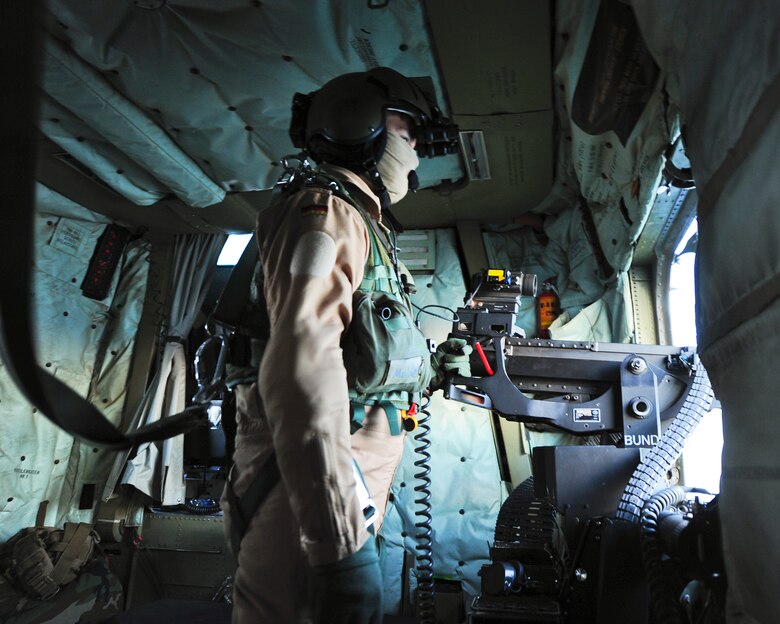 A German Air Force aerial gunner looks out the gunner window of German Air Force CH-53GS helicopter while flying over Southern California during Angel Thunder 2015, June 7, 2015.  Angel Thunder is the world's largest personnel recovery exercise.  D-M hosted 11 partner nations and nine interagencies with a common goal to train personnel recovery forces to prepare, plan, execute and adapt for rescue missions.  (U.S. Air Force photo by Airman 1st Class Chris Massey/Released)