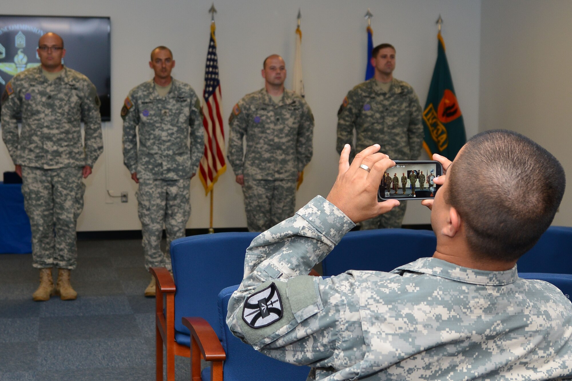 A U.S. Army Soldier photographs Aviation Logistics Noncommissioned Officer Academy instructors during a ceremony at Fort Eustis, Va., June 5, 2015. During the ceremony, the instructors were awarded the Army Instructor Badge. (U.S. Air Force photo by Staff Sgt. Natasha Stannard/Released)