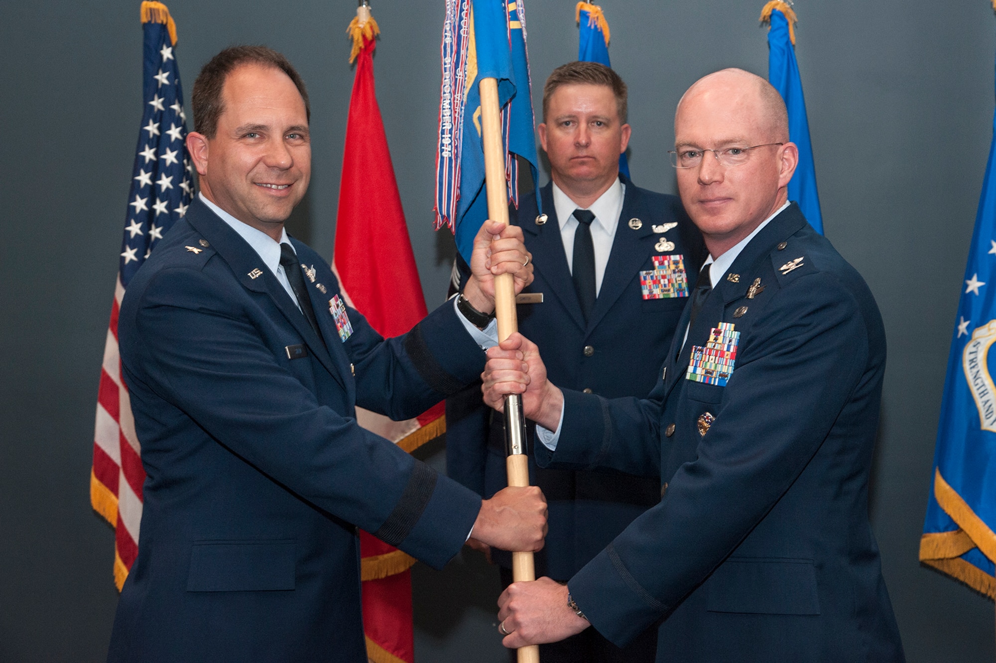 PETERSON AIR FORCE BASE, Colo. – Brig. Gen. John Shaw, 21st Space Wing commander, passes the 21st Operations Group guidon to Col. Troy Endicott, incoming 21st OG commander, during the change of command ceremony June 8 at building 2027. Endicott was stationed at Peterson AFB from 2008–2011 as a 76th Space Control Squadron operations officer and as the 21st Operations Support Squadron commander. He replaces outgoing Col. David Miller. (U.S. Air Force photo by Craig Denton)