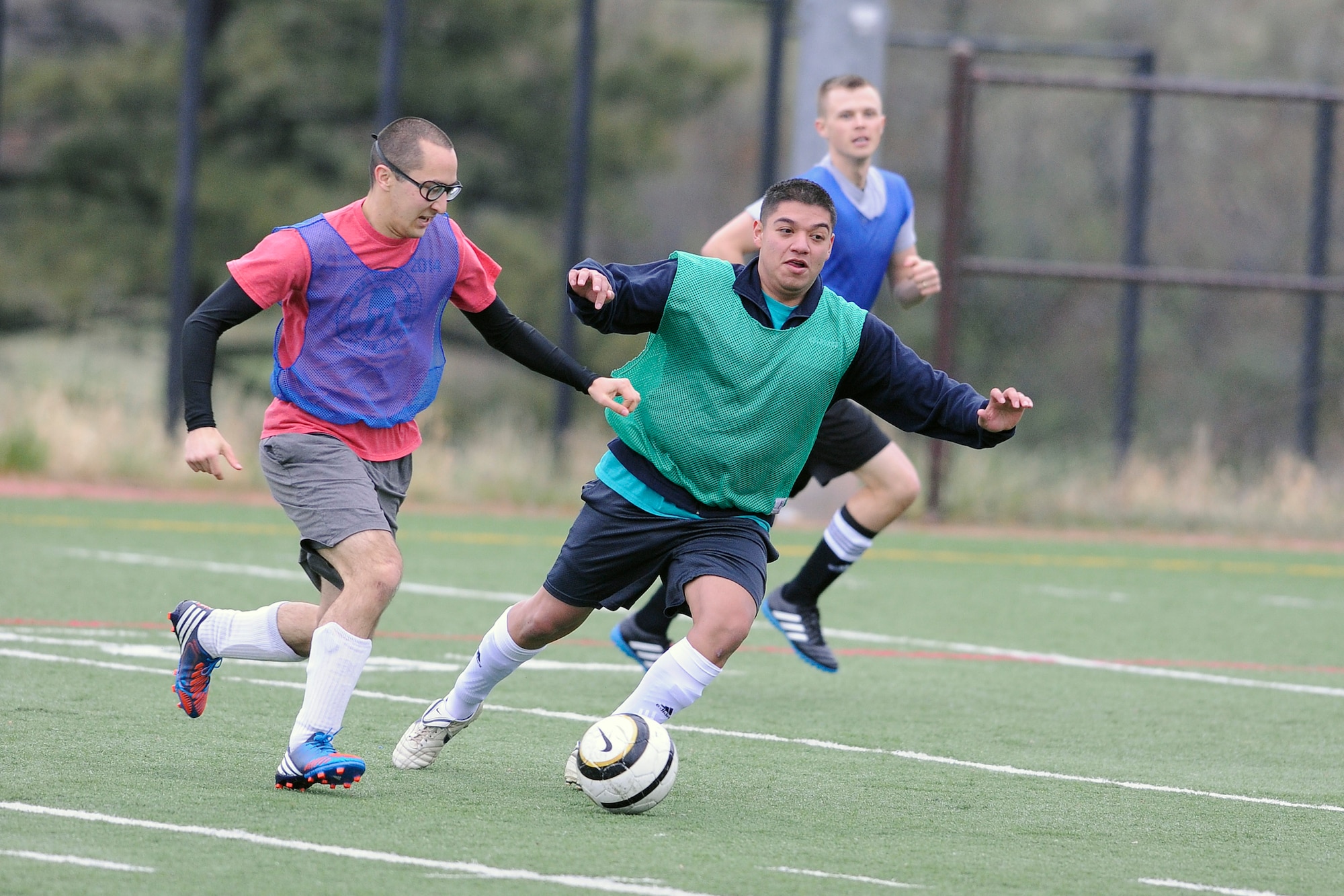 John Cortes, 306th Flying Training Group-10th Communications Squadron intramural soccer team coach, looks to kick to Travis Carr and Dylan Mac Dermot during the U.S. Air Force Academy Intramural Soccer Championship game against the Dean of Faculty here May 21, 2015. (U.S. Air Force photo/Bill Evans) 