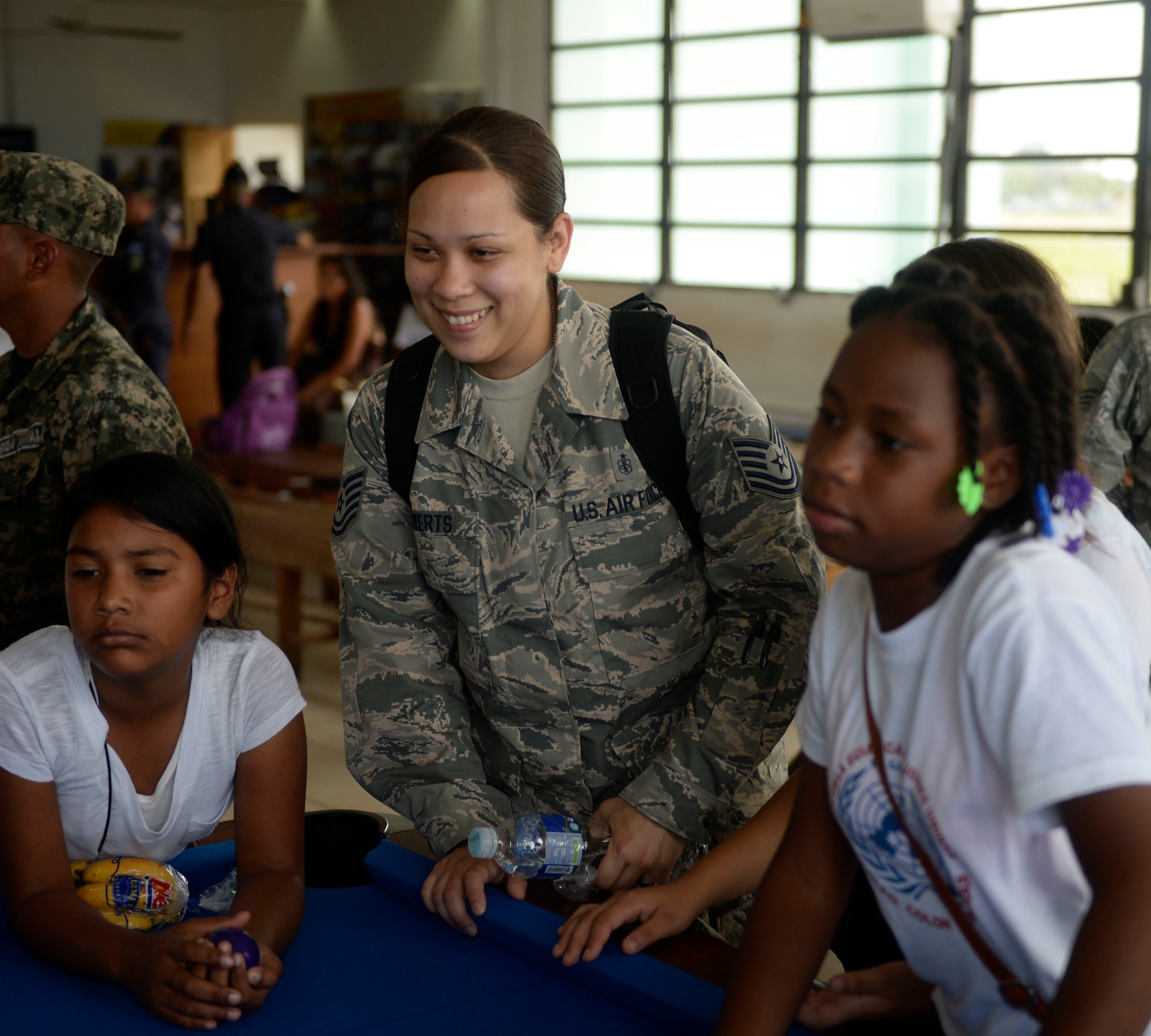 U.S. Tech. Sgt. Tiffany Rewerts, 87th Medical Operations Squadron medical technician, 87th Medical Group, out of Joint Base McGuire-Dix-Lakehurst, N.J., and Abilene, Texas native, spends time playing with children during the Guardians of the Fatherland event at Puerto Castillo Naval Base in Trujillo, Honduras, June 6, 2015. The event was attended my more than 20 NEW HORIZONS Honduras 2015 volunteers. NEW HORIZONS was launched in the 1980s and is an annual joint humanitarian assistance exercise that U.S. Southern Command conducts with a partner nation in Central America, South America or the Caribbean. The exercise improves joint training readiness of U.S. and partner nation civil engineers, medical professionals and support personnel through humanitarian assistance activities. (U.S. Air Force photo by Capt. David J. Murphy/Released)
