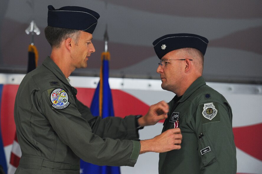 Col. Brian Afflerbaugh, 4th Operations Group commander, presents Lt. Col. David Evans, outgoing 4th Training Squadron commander, with a Meritorious Service Medal during the 4th TS change of command ceremony, June 5, 2015, at Seymour Johnson Air Force Base, North Carolina. Evans relinquished command to Lt. Col. Trent Tripple. (U.S. Air Force photo/Airman 1st Class Aaron J. Jenne)