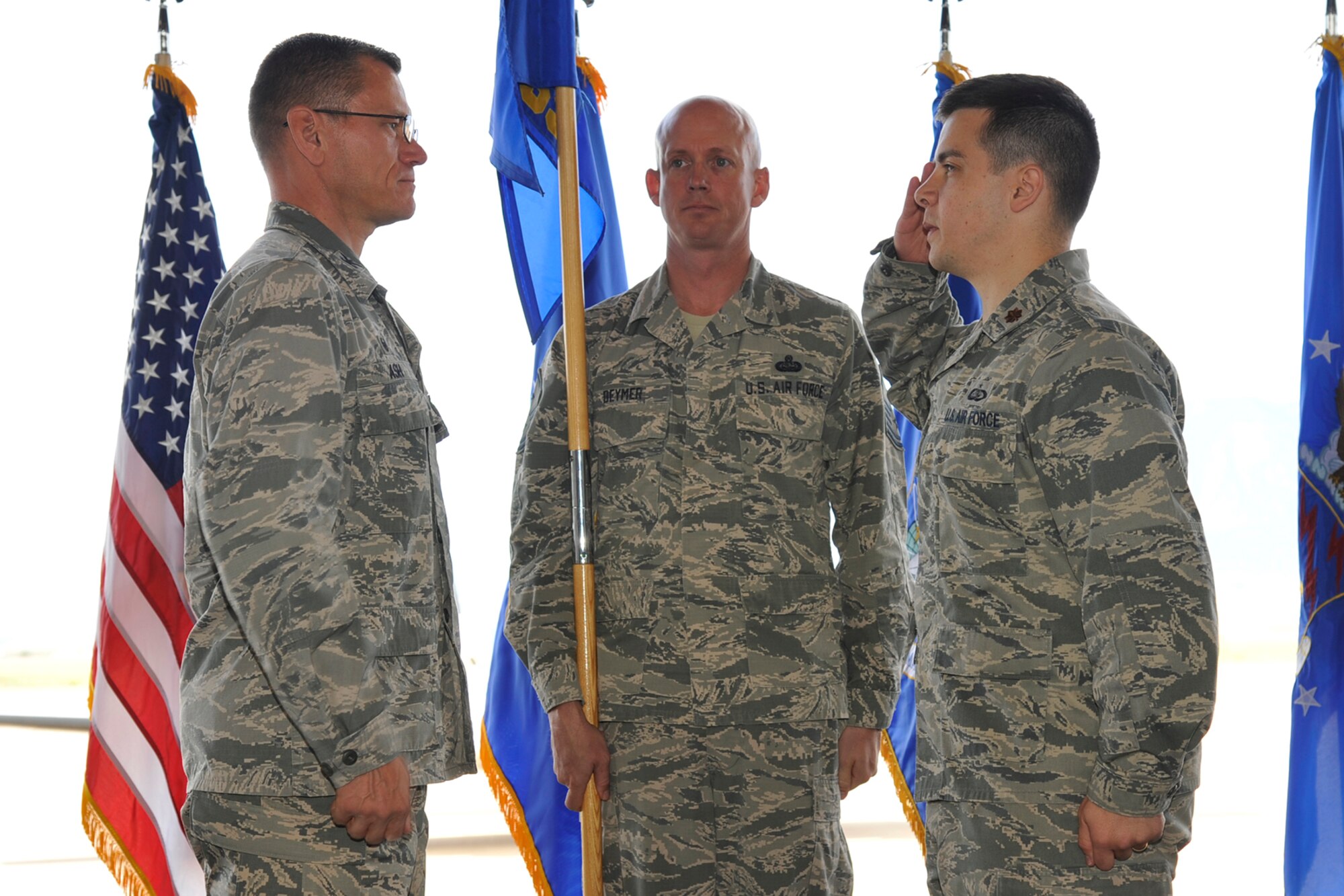 PETERSON AIR FORCE BASE, Colo. – Maj. David Wilson (right) accepts command of the 21st Force Support Squadron from Col. Reginald Ash, 21st Mission Support Group commander, June 2 in Hangar 133. Wilson arrives at Peterson after being a legislative affairs fellow in Washington, D.C., and replaces Lt. Col. Tammy Schlichenmaier, outgoing commander, who will now be the executive officer for Maj. Gen. David Buck, Headquarters Air Force Space Command vice commander. (U.S. Air Force photo by Robb Lingley)