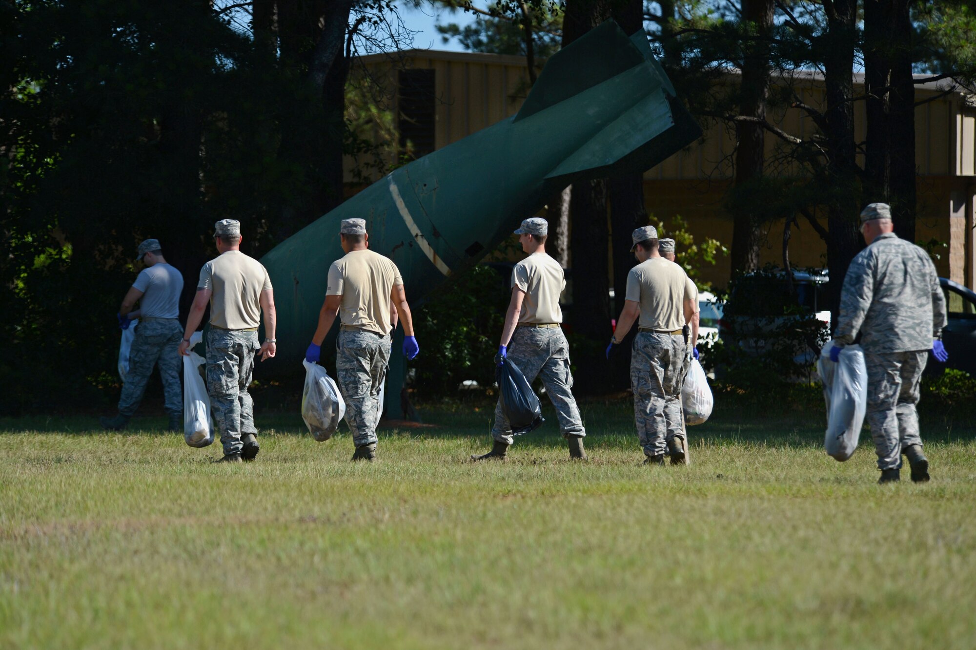 U.S. Air Force Airmen assigned to the 20th Civil Engineer Squadron explosive ordinance disposal, finish picking up at trash at Shaw Air Force Base, S.C., Jun. 1, 2015. The base-wide clean up day consisted of each squadron picking up trash around their buildings and across the base to help maintain a clean environment. (U.S. Air Force photo by Senior Airman Jensen Stidham/Released)