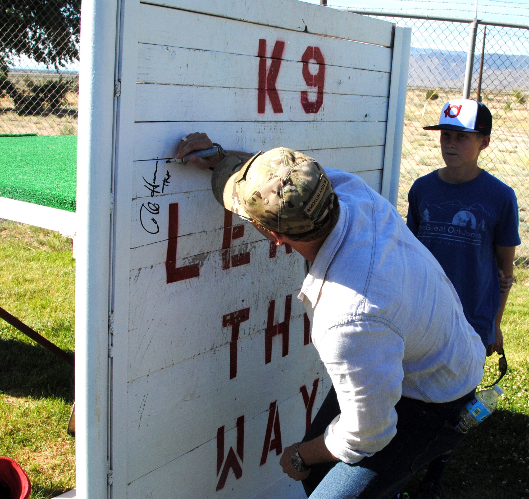 Actor Cole Hauser signs "the wall" at the 377th Security Forces Group's military working dog section June 3. Hauser visited Kirtland as part of a USO-sponsored event where he screened an unreleased episode of the DirectTV series "Rogue," in which he is one of the stars. (Photo by Jim Fisher)
