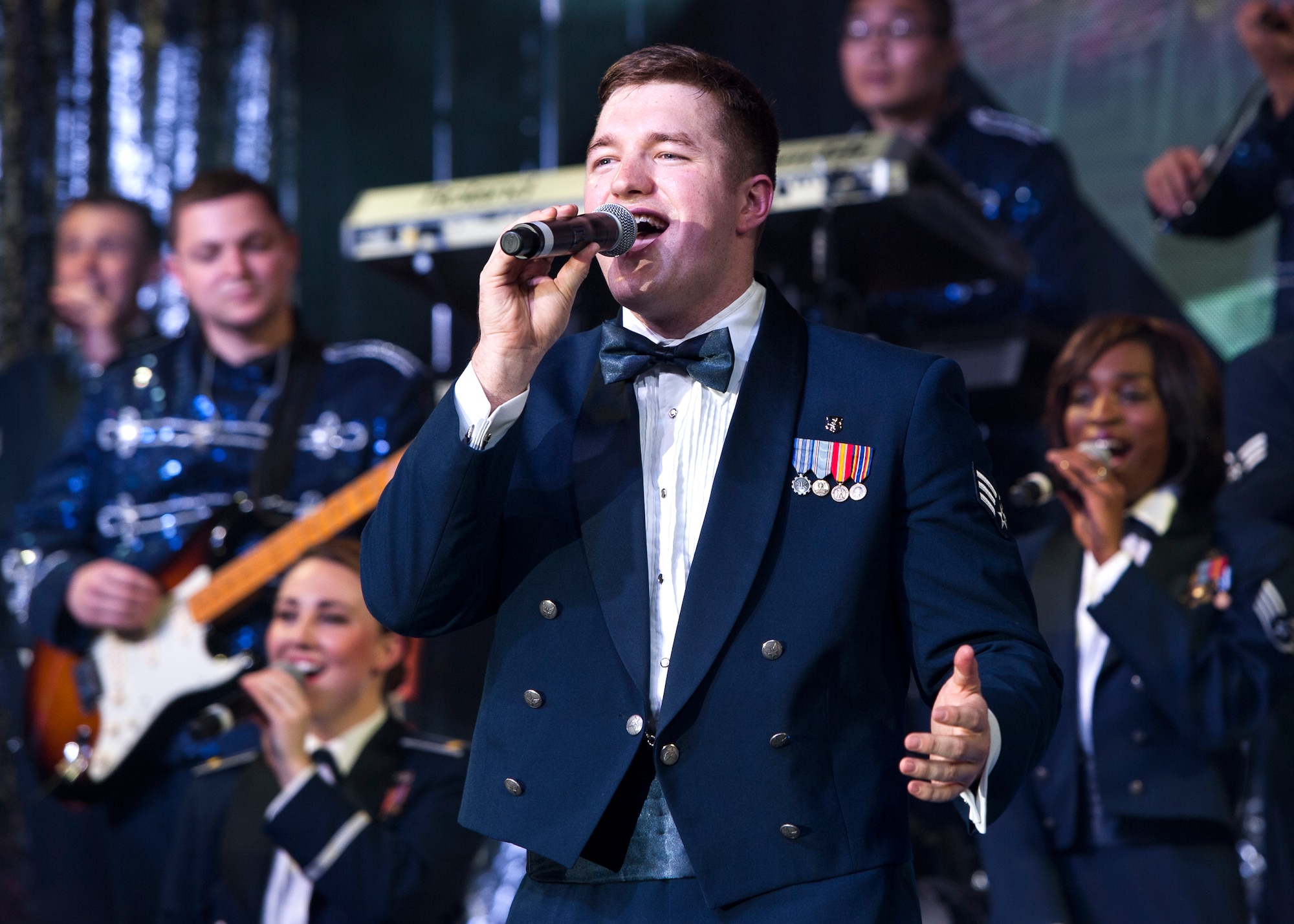 Senior Airman Jeremy Karcher sings a solo during Tops in Blue’s Freedom’s Song World Tour at the Emerald Coast Convention Center, June 6 in Fort Walton Beach, Fla. The Galion, Ohio native was one of 37 Airmen selected for the special unit based on his ability to entertain.  The TIB team is also the “road crew” for each show. Managed by seven technical personnel, they are responsible for the transporting and setting up more than 65,000 pounds of stage equipment.  TIB’s mission is to provide entertainment to military personnel and their families at home and abroad. (U.S. Air Force photo/Ilka Cole)