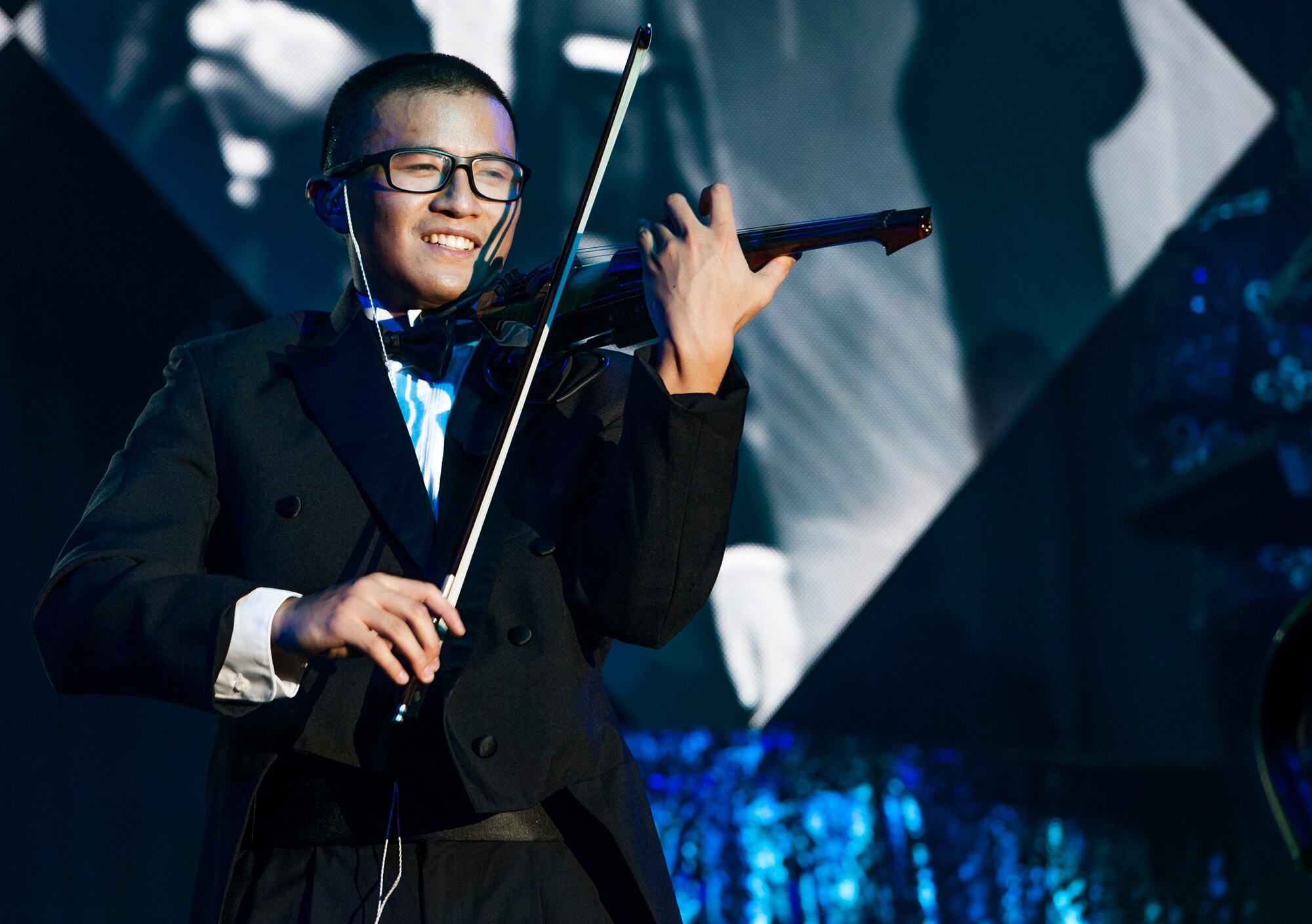 1st Lt. Oliver Chang plays the violin during Tops in Blue’s Freedom’s Song World Tour at the Emerald Coast Convention Center, June 6 in Fort Walton Beach, Fla. The Ann Arbor, Mich., native was one of 37 Airmen selected for the special unit based on his ability to entertain.  The TIB team is also the “road crew” for each show. Managed by seven technical personnel, they are responsible for the transporting and setting up more than 65,000 pounds of stage equipment.  TIB’s mission is to provide entertainment to military personnel and their families at home and abroad.  (U.S. Air Force photo/Ilka Cole)