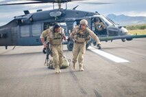 U.S. Airmen from the 38th Rescue Squadron out of Moody Air Force Base, Ga., drag a simulated casualty towards a C-130 Hercules aircraft assigned to the Wyoming Air National Guard's 153rd Airlift Wing during a mission for the exercise Angel Thunder 2015 at Davis-Monthan Air Force Base, Ariz., June 7, 2015. Angel Thunder is the largest and most realistic joint service, multinational, inter-agency combat search and rescue exercise designed to provide training for personnel recovery assets using a variety of scenarios to simulate deployment conditions and contingencies. Personnel recovery forces will train through the full spectrum of personnel recovery capabilities with ground recovery personnel, air assets, Special Forces teams and federal agents. (U.S. Air National Guard photo by Tech. Sgt. John Galvin/Released)