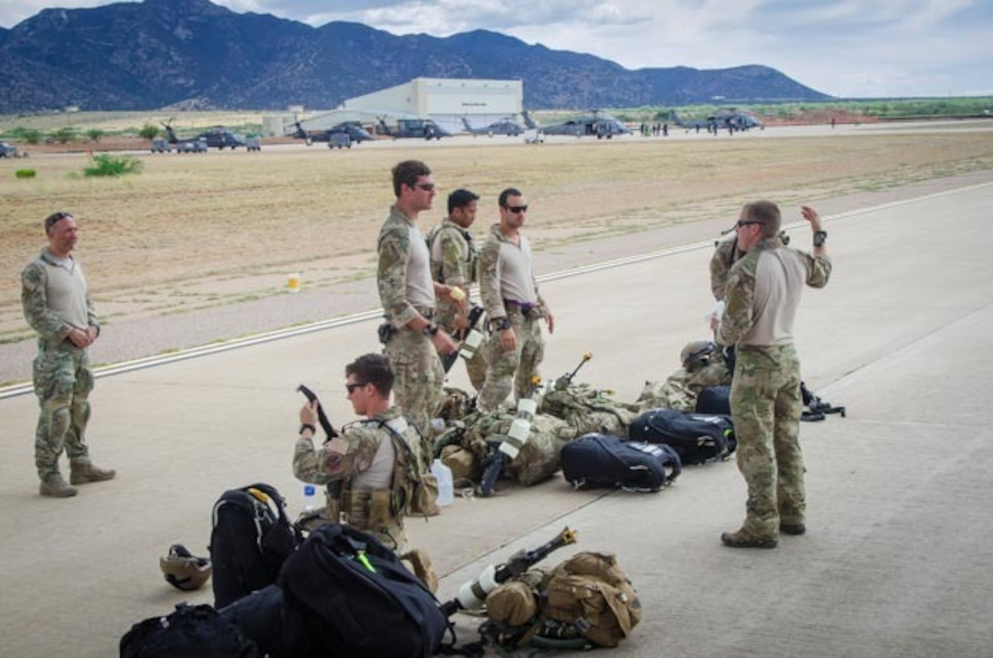 U.S. Airmen from the 38th Rescue Squadron out of Moody Air Force Base, Ga., discuss their upcoming jump prior to boarding a C-130 Hercules aircraft from the Wyoming Air National Guard’s 153rd Airlift Wing June 7, 2015, at Davis-Monthan Air Force Base, Ariz. The jump was part of the exercise Angel Thunder 2015, which is the largest and most realistic joint service, multinational, interagency combat search and rescue exercise designed to provide training for personnel recovery assets. The exercise uses a variety of scenarios to simulate deployment conditions and contingencies. Personnel recovery forces will train through the full spectrum of personnel recovery capabilities with ground recovery personnel, air assets, Special Forces teams and federal agents. (U.S. Air National Guard photo by Tech. Sgt. John Galvin/Released)
