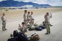 U.S. Airmen from the 38th Rescue Squadron out of Moody Air Force Base, Ga., discuss their upcoming jump prior to boarding a C-130 Hercules aircraft from the Wyoming Air National Guard’s 153rd Airlift Wing June 7, 2015, at Davis-Monthan Air Force Base, Ariz. The jump was part of the exercise Angel Thunder 2015, which is the largest and most realistic joint service, multinational, interagency combat search and rescue exercise designed to provide training for personnel recovery assets. The exercise uses a variety of scenarios to simulate deployment conditions and contingencies. Personnel recovery forces will train through the full spectrum of personnel recovery capabilities with ground recovery personnel, air assets, Special Forces teams and federal agents. (U.S. Air National Guard photo by Tech. Sgt. John Galvin/Released)