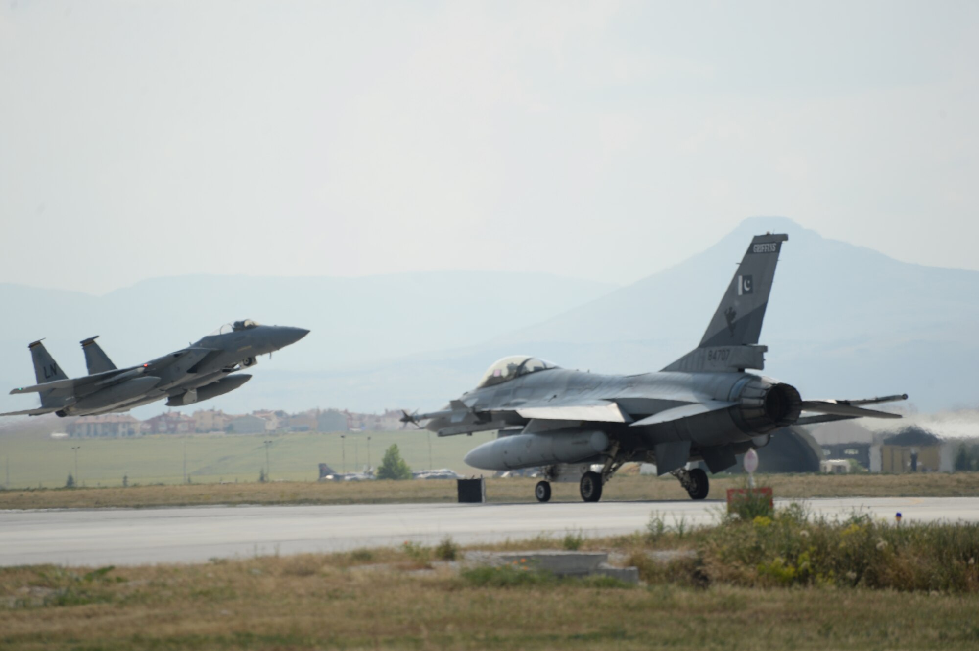 An F-15C Eagle from the 493rd Fighter Squadron, Royal Air Force Lakenheath, England, takes off as a Pakistan Air Force F-16 Fighting Falcon taxis to the runway during Anatolian Eagle 15 at 3rd Main Jet Base, Turkey, June 8, 2015. Anatolian Eagle is a two-week flying training exercise involving U.S. Air Forces in Europe units and multiple NATO partners. (U.S. Air Force photo by Tech. Sgt. Eric Burks/Released)