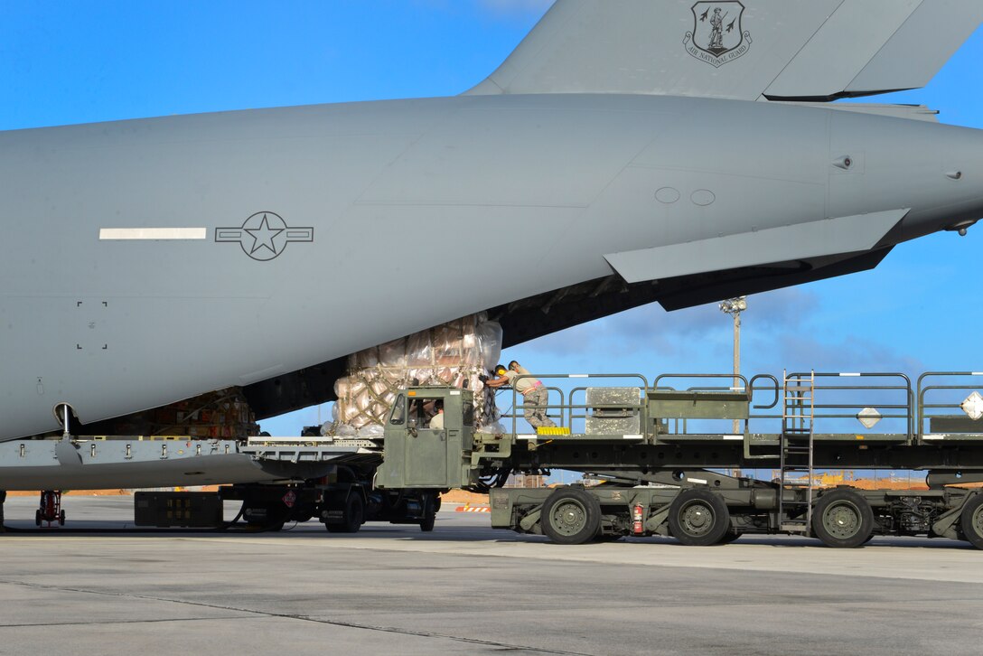 Aerial port Airmen from the 734th Air Mobility Squadron push cargo onto a C-17 Globemaster III April 18, 2015, at Andersen Air Force Base, Guam. The 734th AMS transported approximately 10,792 tons of cargo and 32,200 passengers last year. (U.S. Air Force photo by Senior Airman Katrina M. Brisbin/Released)